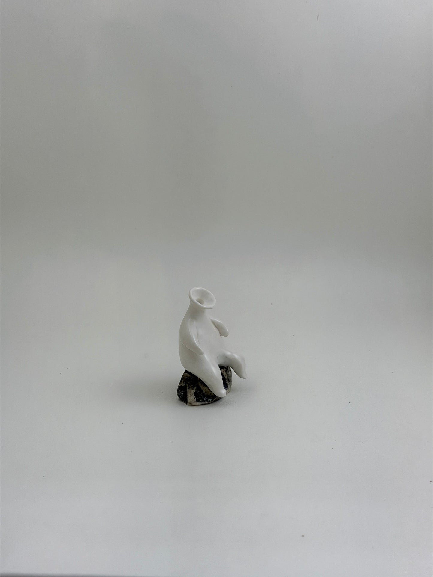 Tiny Vase Person Sitting on a Rock